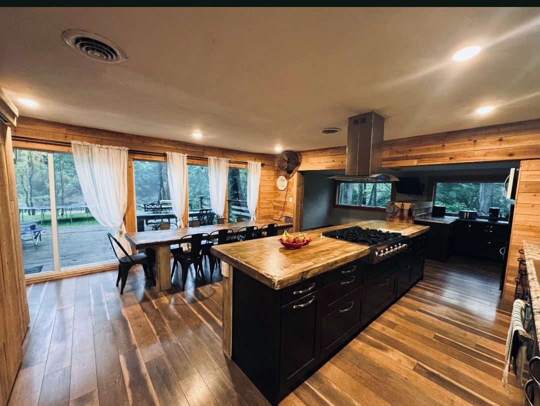Large open kitchen with a butcher-block island and long dining table at the Bear Creek sober living home, Miamisburg Ohio