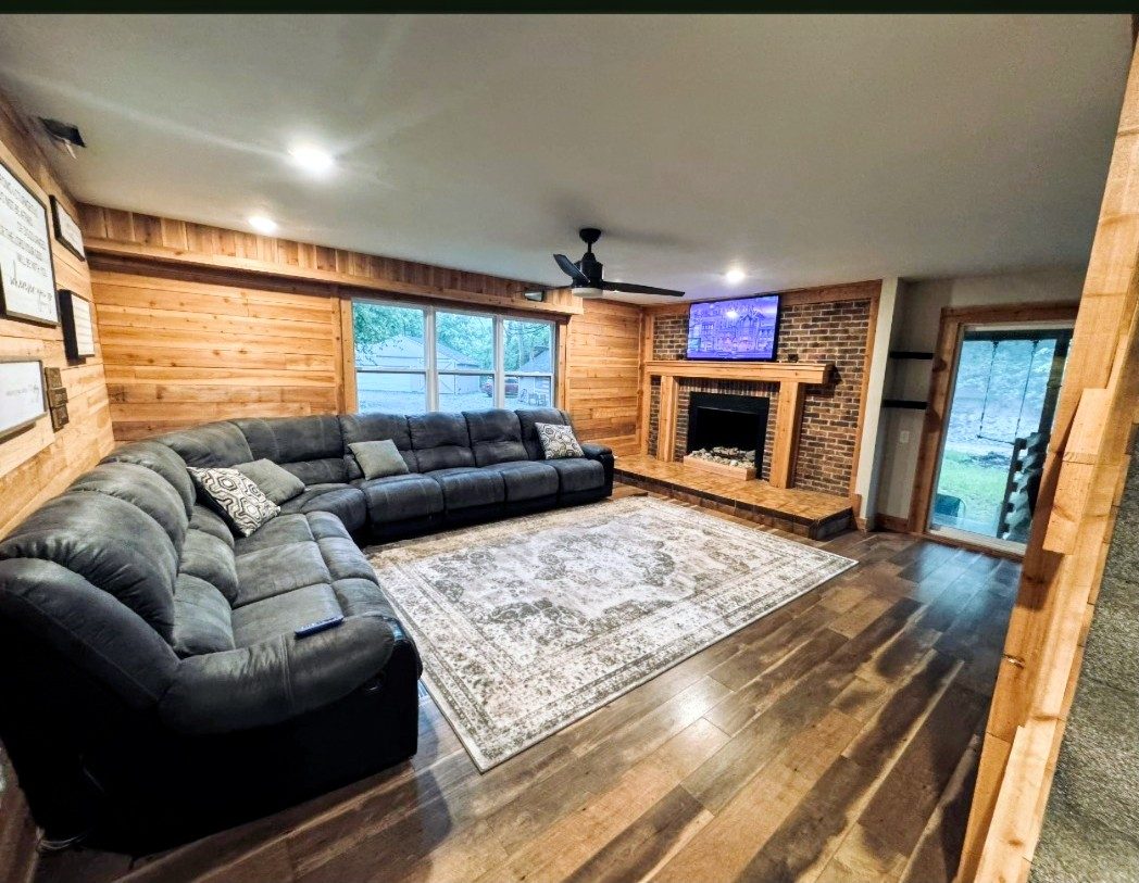 Family room with a brick fireplace and large sectional sofa at the Bear Creek recovery home in Miamisburg, Ohio